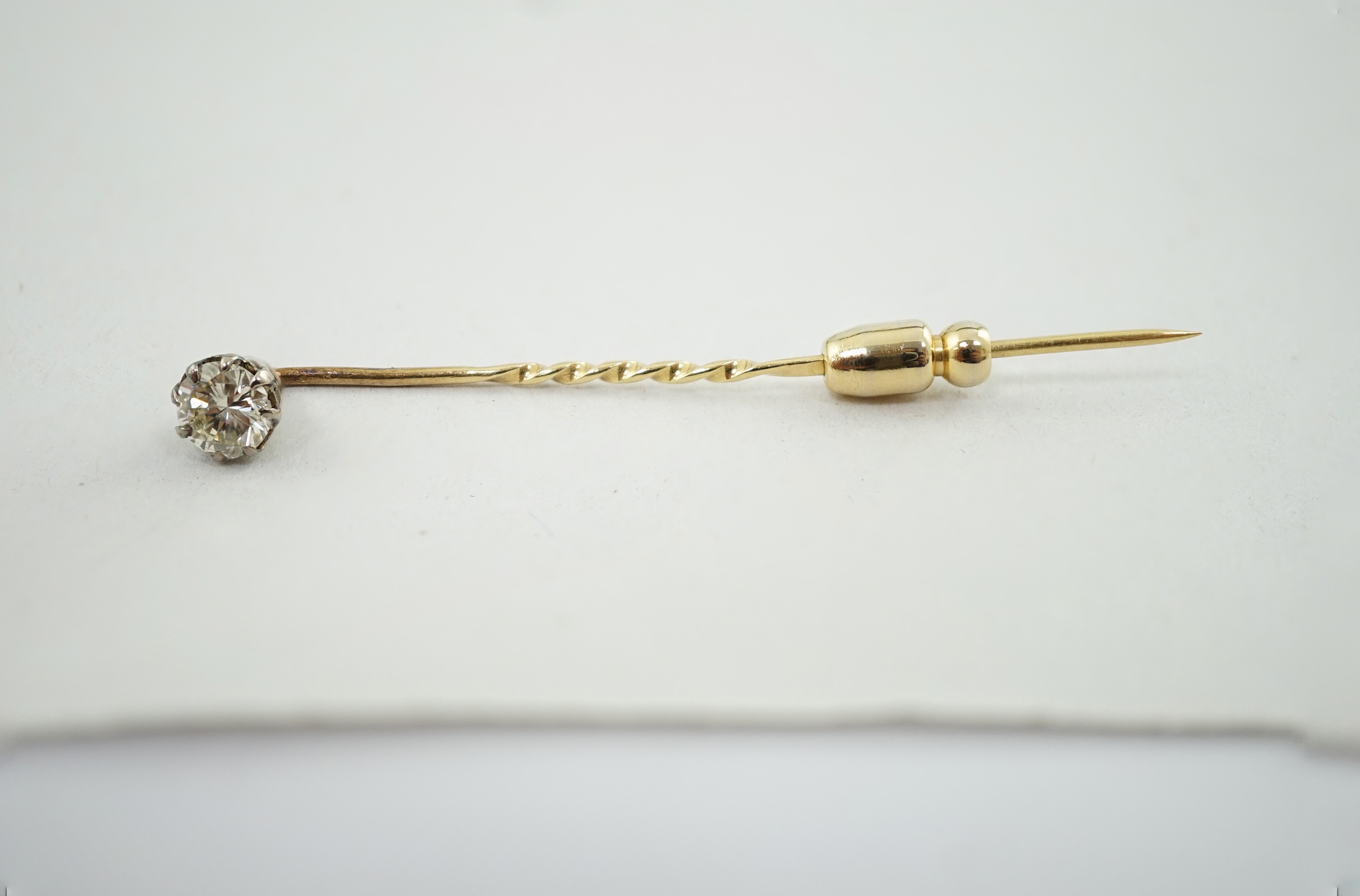 A late Victorian gold and solitaire diamond set stick pin